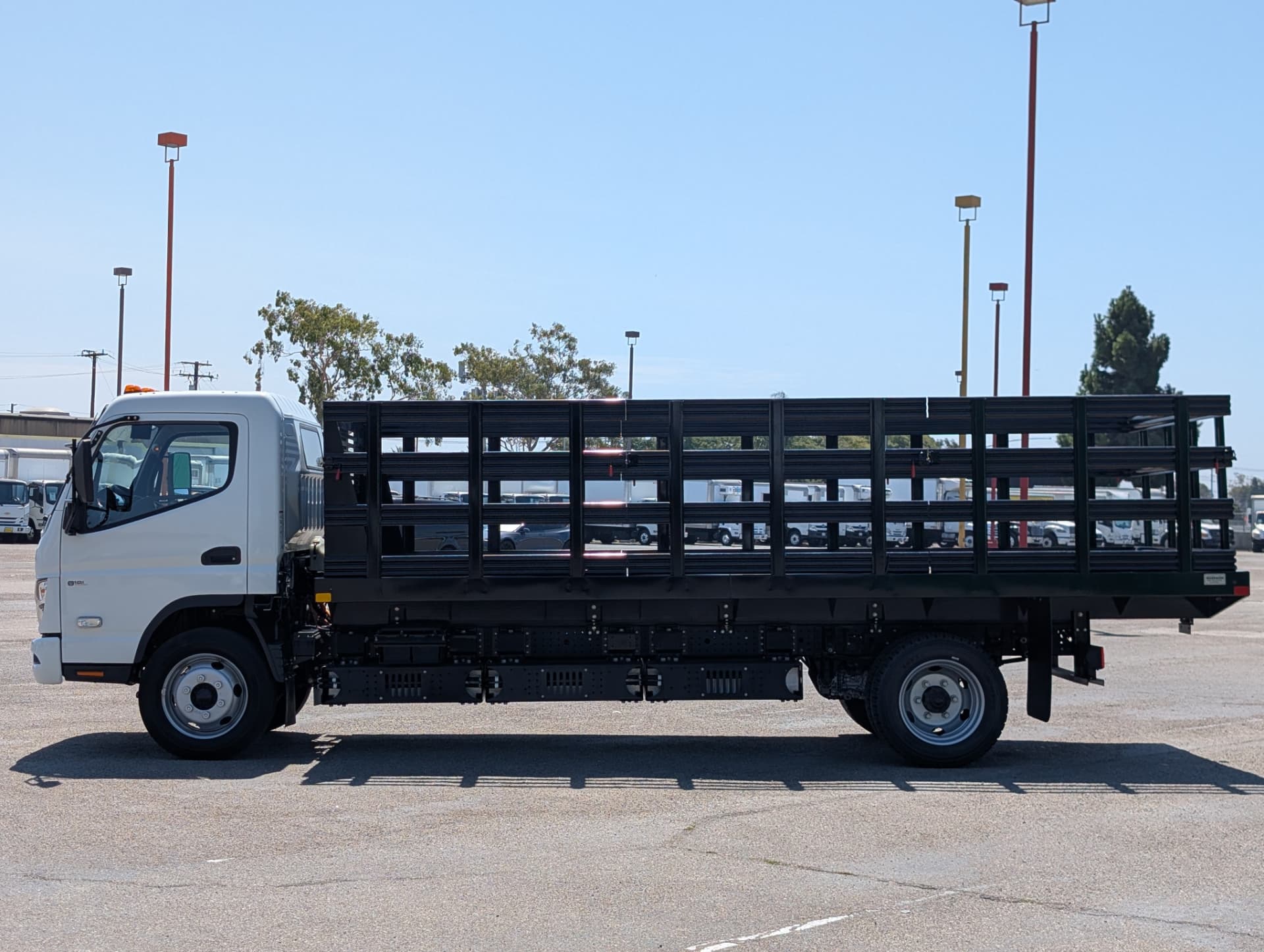 White RIZON e18L Class 5 electric stakebed truck with black stake body